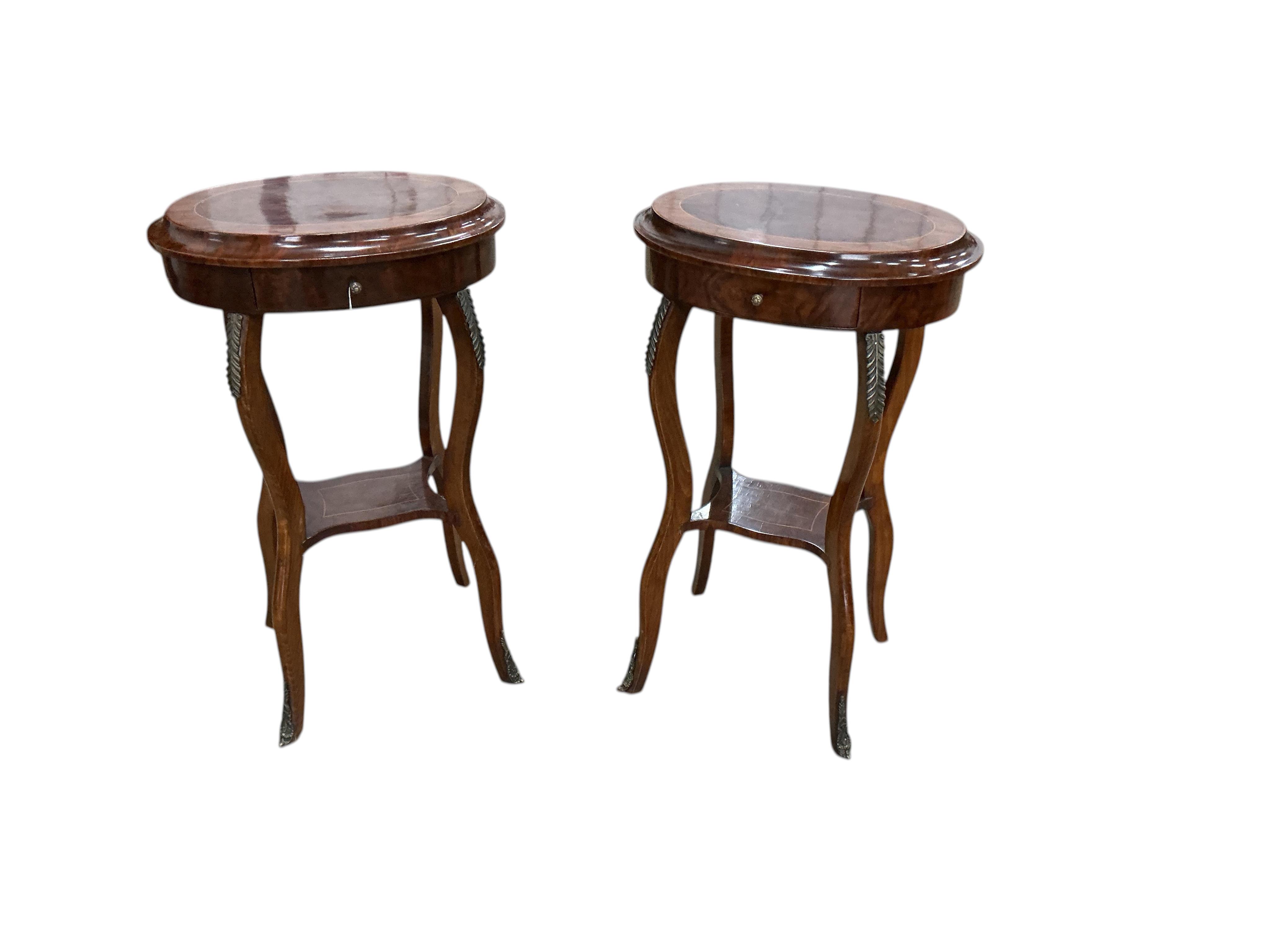 A pair of Louis XVI style oval gilt metal mounted walnut two tier occasional tables, width 45cm, depth 33cm, height 76cm